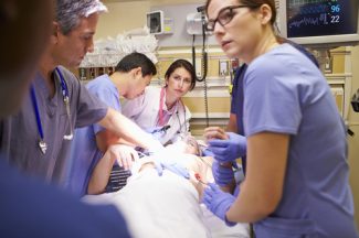 emergency room nurse practitioners working on a patient